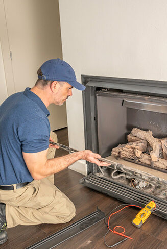 Stock photo man completing gas fireplace installation - Dunrite Chimney Centereach NY Man completing gas fireplace installation - Dunrite Chimney