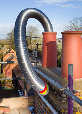 Stock photo of new chimney liner hanging out of chimney - Dunrite Chimney Cleareach NY New chimney liner hanging out of chimney - Dunrite Chimney