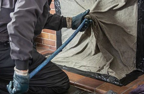 Chimney sweep cleaning inside of a fireplace - Dunrite Chimney