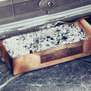 a fireplace ash tray filled with wood ash