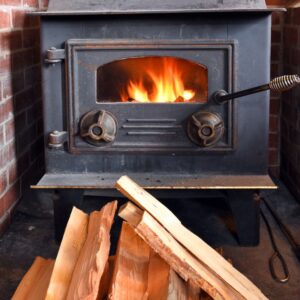 a pile of wood in front of a cast iron wood stove